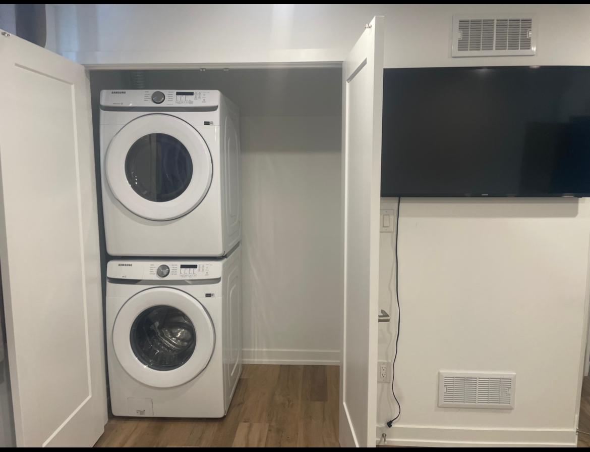 In-unit stacked washer and dryer with a wall-mounted smart TV