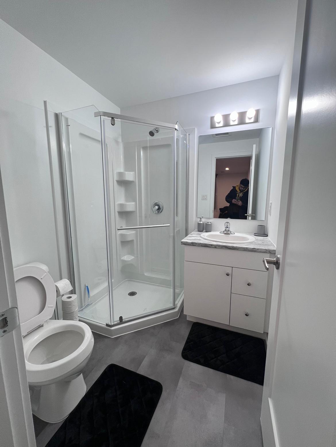Full bathroom with a corner glass shower and vanity